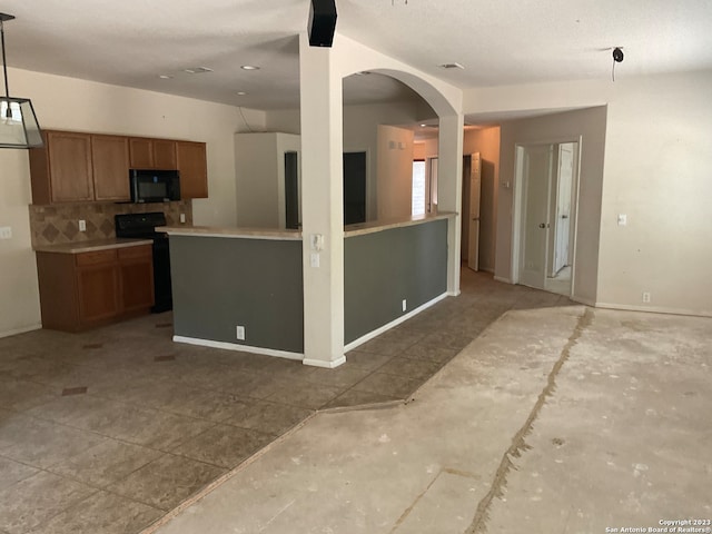 kitchen with electric range oven, backsplash, and hanging light fixtures