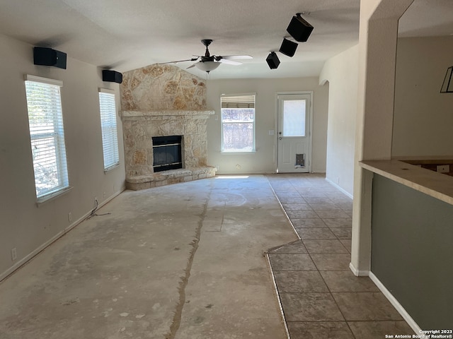 unfurnished living room with a textured ceiling, a healthy amount of sunlight, ceiling fan, and rail lighting