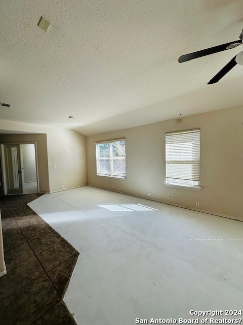 unfurnished room with ceiling fan and a textured ceiling