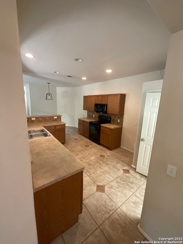 kitchen featuring decorative light fixtures, sink, light tile floors, and black appliances