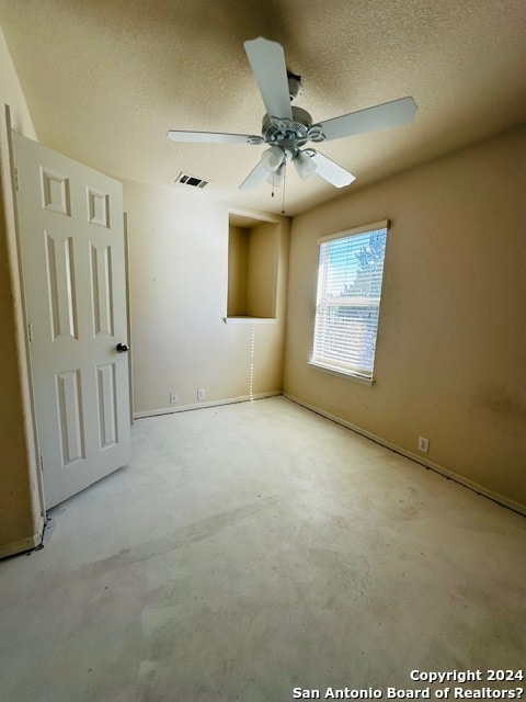 unfurnished room featuring ceiling fan and a textured ceiling