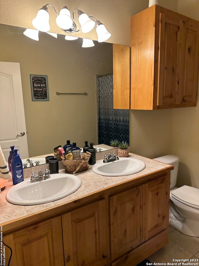 bathroom with tile flooring, toilet, and dual bowl vanity