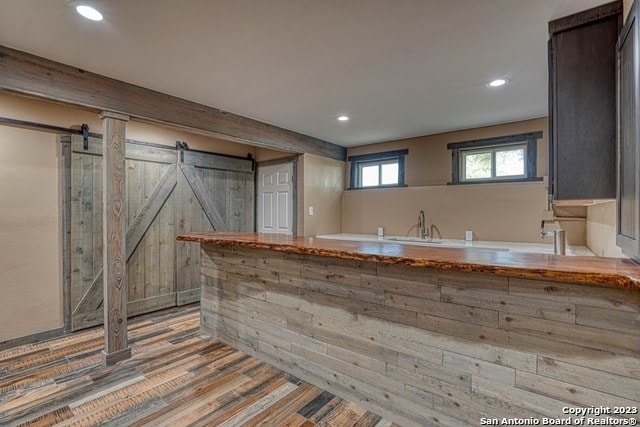 kitchen with sink, hardwood / wood-style flooring, and a barn door