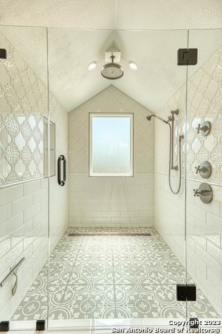 bathroom with lofted ceiling, walk in shower, and a textured ceiling