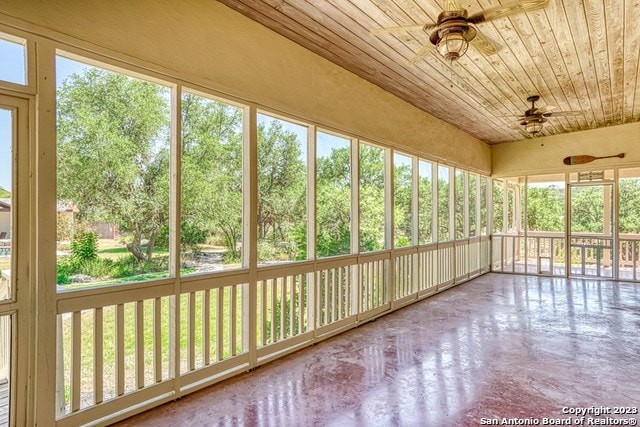 unfurnished sunroom with a wealth of natural light, ceiling fan, and wooden ceiling