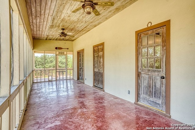 unfurnished sunroom featuring wood ceiling and ceiling fan