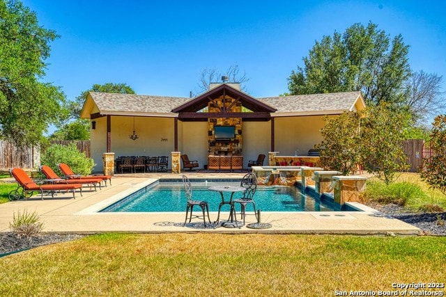 view of pool featuring a lawn, pool water feature, and a patio area