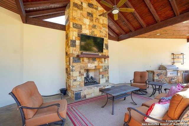 view of patio / terrace with area for grilling, an outdoor living space with a fireplace, ceiling fan, and exterior kitchen