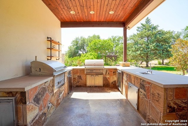 view of patio featuring area for grilling, sink, and an outdoor kitchen