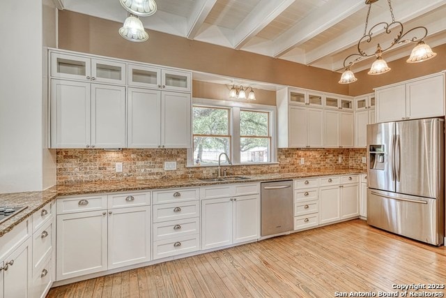 kitchen with beamed ceiling, appliances with stainless steel finishes, sink, white cabinetry, and pendant lighting