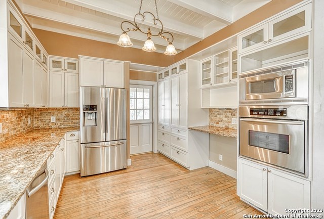 kitchen featuring tasteful backsplash, appliances with stainless steel finishes, light hardwood / wood-style floors, and beamed ceiling