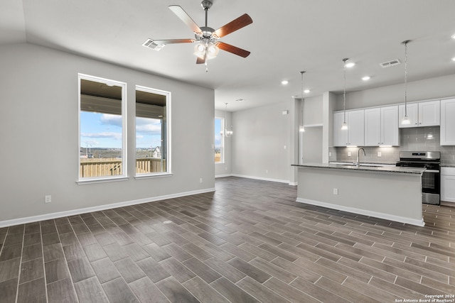 kitchen with tasteful backsplash, ceiling fan, stainless steel range oven, sink, and white cabinets