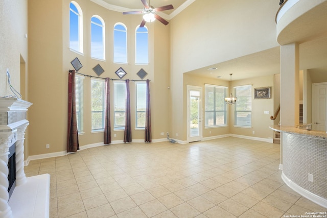 unfurnished living room featuring light tile floors, a high ceiling, and ceiling fan with notable chandelier