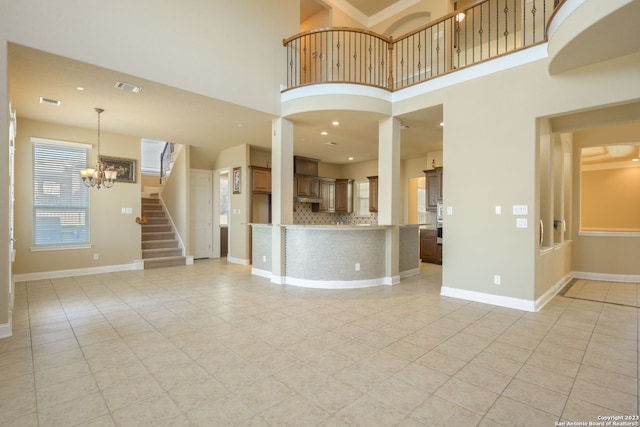 interior space with an inviting chandelier, light tile floors, and a high ceiling