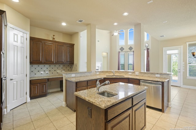 kitchen with a kitchen island with sink, sink, light tile floors, and stainless steel dishwasher