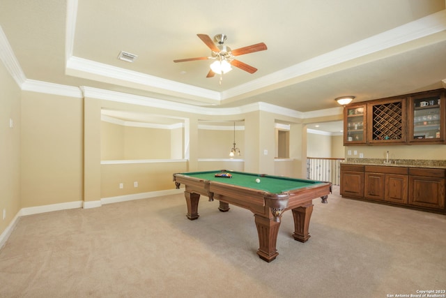 rec room with pool table, a tray ceiling, ceiling fan, crown molding, and light colored carpet