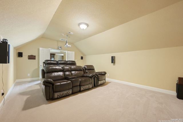 carpeted home theater room featuring vaulted ceiling and a textured ceiling