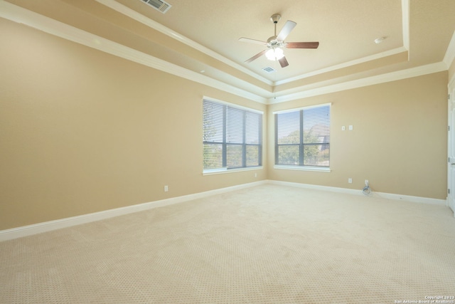 unfurnished room featuring crown molding, light colored carpet, ceiling fan, and a tray ceiling