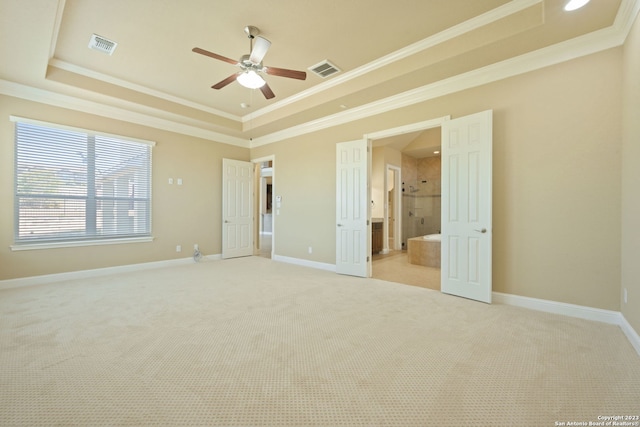 carpeted empty room with a raised ceiling, ornamental molding, and ceiling fan