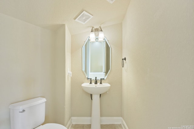 bathroom featuring toilet and tile flooring