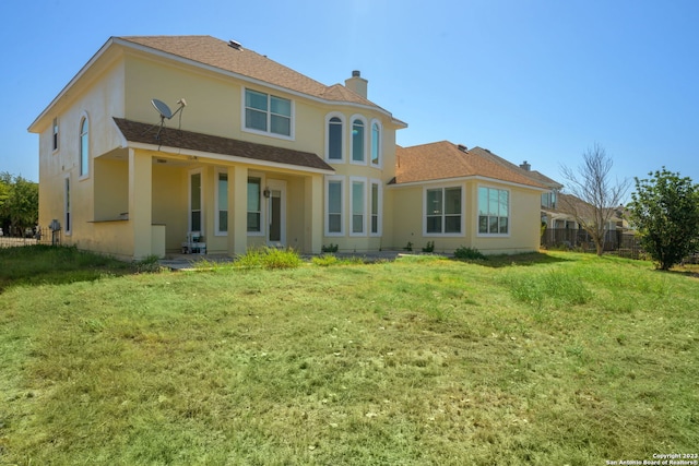 rear view of property with a yard