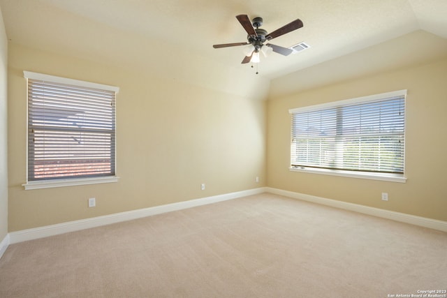 carpeted spare room featuring vaulted ceiling and ceiling fan