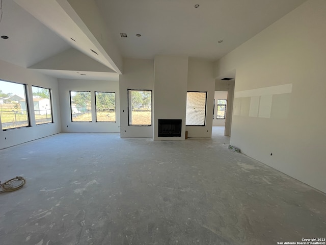 unfurnished living room with high vaulted ceiling