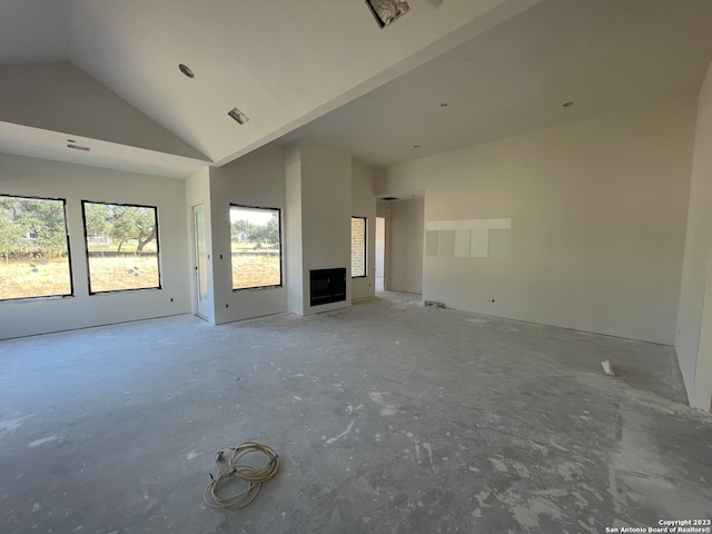 unfurnished living room featuring high vaulted ceiling