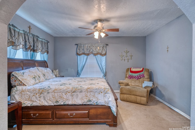 carpeted bedroom with a textured ceiling and ceiling fan