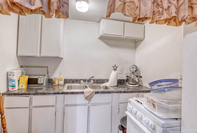 kitchen featuring sink, a textured ceiling, and white cabinetry