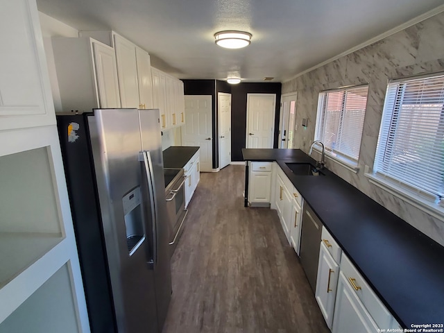 kitchen featuring sink, crown molding, dark hardwood / wood-style flooring, white cabinets, and appliances with stainless steel finishes