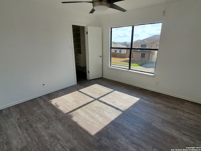 unfurnished room with ceiling fan and dark wood-type flooring