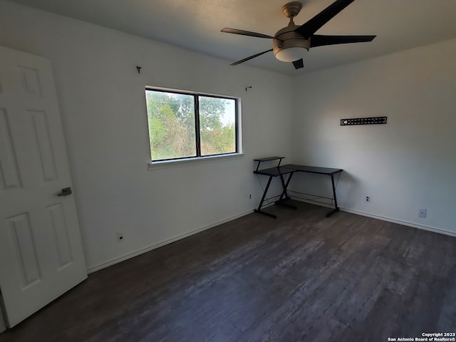 spare room with dark hardwood / wood-style floors and ceiling fan