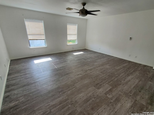 empty room with ceiling fan and dark hardwood / wood-style flooring