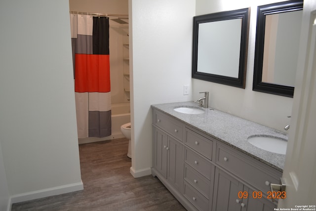 full bathroom featuring shower / tub combo, double sink vanity, toilet, and hardwood / wood-style flooring