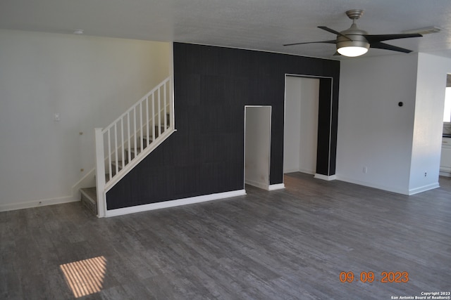 unfurnished living room featuring dark hardwood / wood-style floors and ceiling fan