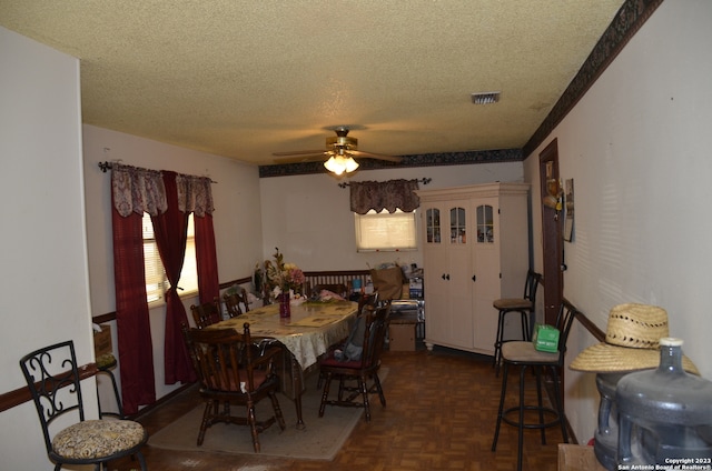 dining room with a textured ceiling, dark parquet flooring, and ceiling fan