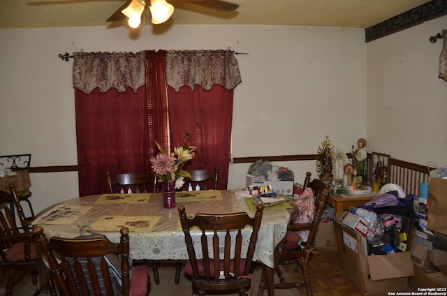 dining space with a textured ceiling, ceiling fan, and dark parquet flooring