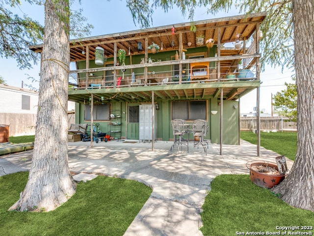 rear view of house with a lawn and a patio area