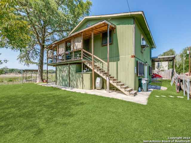 rear view of house featuring a lawn