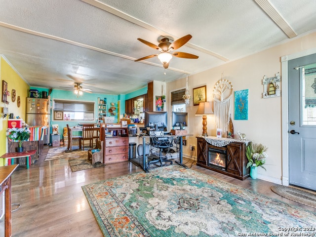 home office featuring dark wood-type flooring, a textured ceiling, and ceiling fan