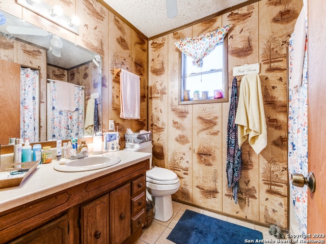 bathroom with toilet, large vanity, tile floors, and a textured ceiling