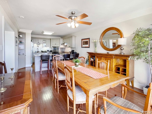 dining area with sink, ceiling fan, dark hardwood / wood-style flooring, and ornamental molding