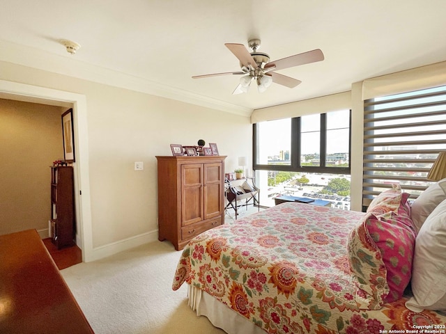 carpeted bedroom featuring multiple windows, ceiling fan, and ornamental molding