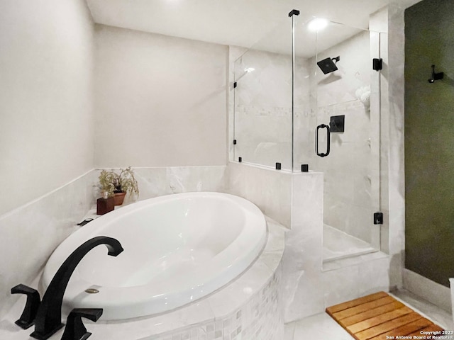 bathroom with shower with separate bathtub and tile floors