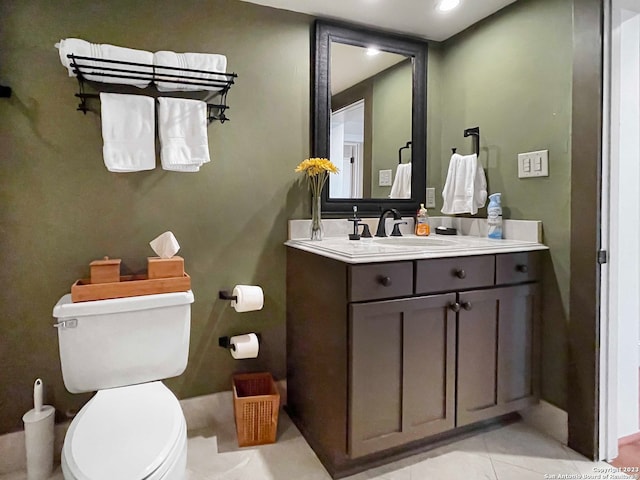 bathroom with toilet, tile flooring, and vanity