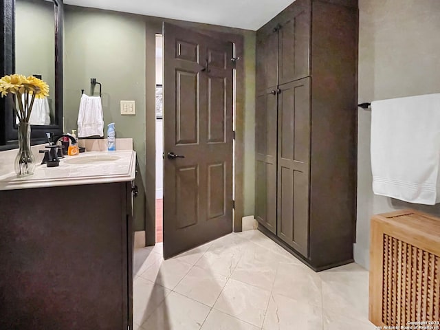 bathroom featuring tile floors, large vanity, and radiator