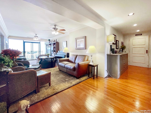 living room featuring ornamental molding, light hardwood / wood-style floors, and ceiling fan