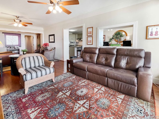 living room with wood-type flooring, ceiling fan, and ornamental molding