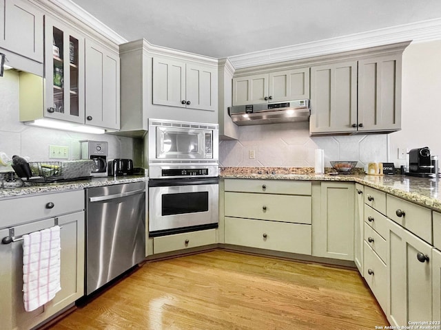 kitchen featuring crown molding, light wood-type flooring, tasteful backsplash, and stainless steel appliances